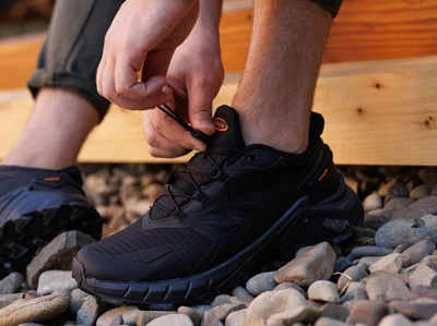 Мужские черные кроссовки с резиновыми шнурками и водоотталкивающим верхом на ноге.