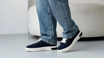 Мужские темно-синие кеды с белой подошвой на модели в джинсах