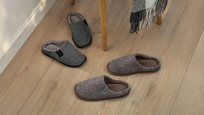 Мужские серые домашние тапочки с мягкой подкладкой, вид сверху на деревянном полу