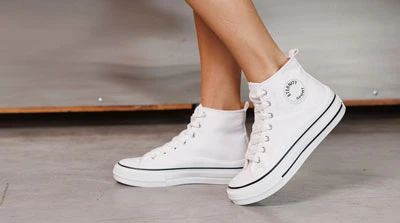 Белые высокие женские кеды со шнуровкой на плоской подошве, вид сбоку