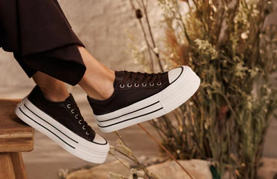 Коричневі жіночі кеди зі шнурівкою на високій білій підошві, вигляд збоку