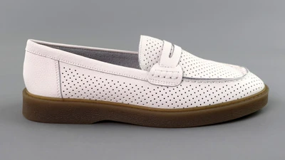 Жіночі білі лофери з перфорацією, вигляд збоку на сірому фоні