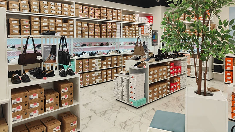 Торговий зал магазину Sezon у Мукачеві з полицями взуття, сумками та аксесуарами