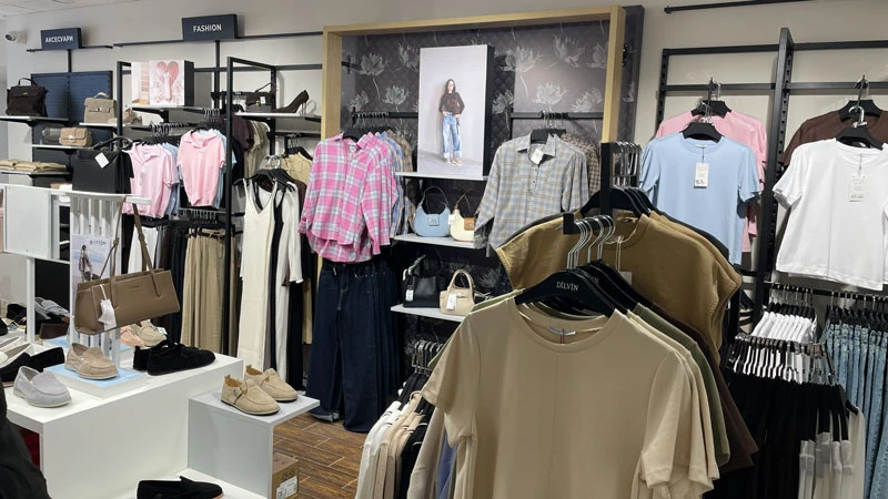 Fashion-зона магазина Sezon Надворная с одеждой, аксессуарами и обувью для покупателей