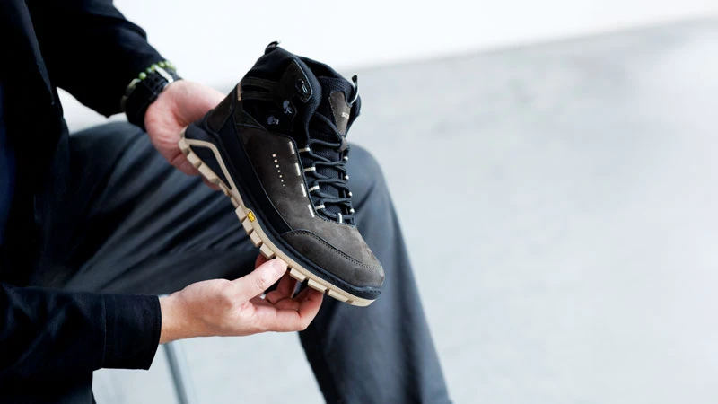 Трекінгові черевики з водовідштовхувальним захистом у руці чоловіка