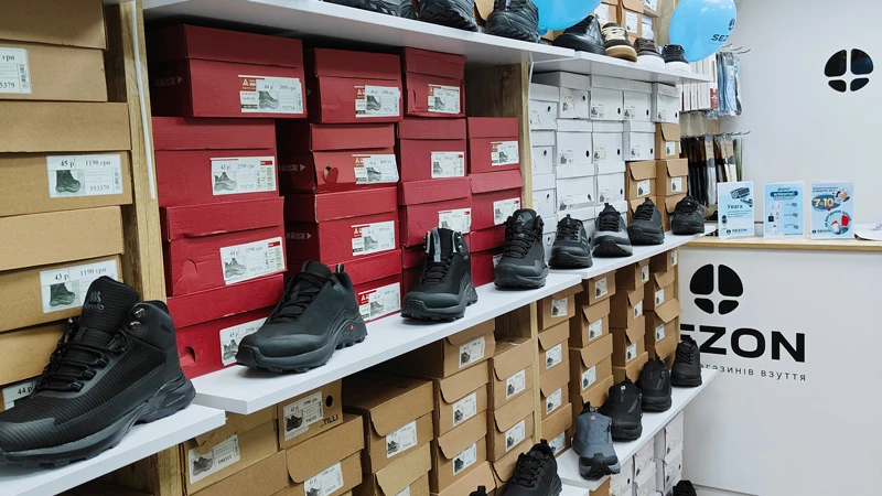Відкриття фірмового магазину Sezon у Виноградові – полиці з взуттям та коробками в торговому залі