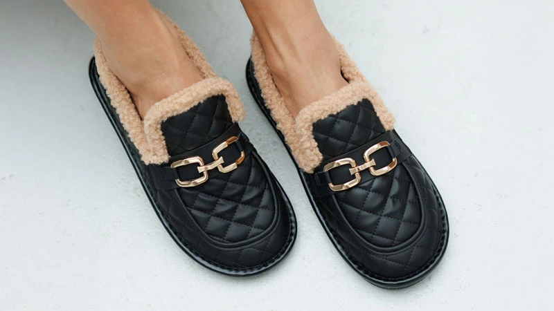 Женские чёрные слеперы из экокожи с меховой подкладкой и металлическим декором — пример обуви из экокожи