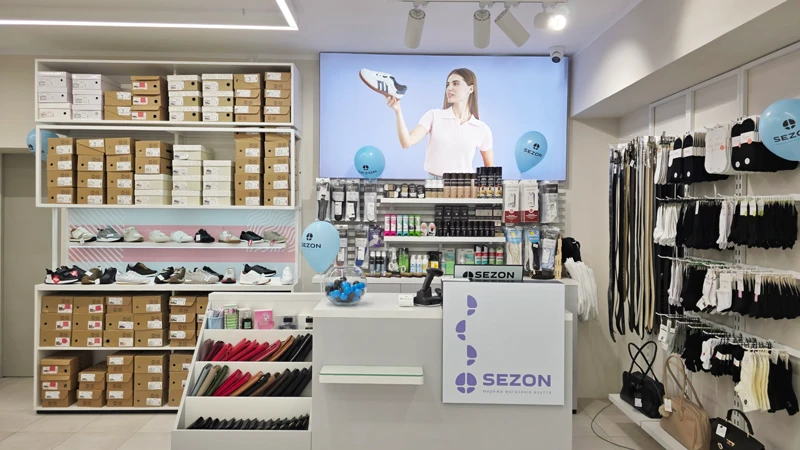 Интерьер нового магазина Sezon в Луцке на улице Леси Украинки, 11: кассовая зона, средства по уходу за обувью, полки с обувью и аксессуарами